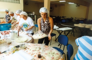 Com a mÃƒÂ£o na massa, produzindo pizzas na campanha em prol do CAPS.